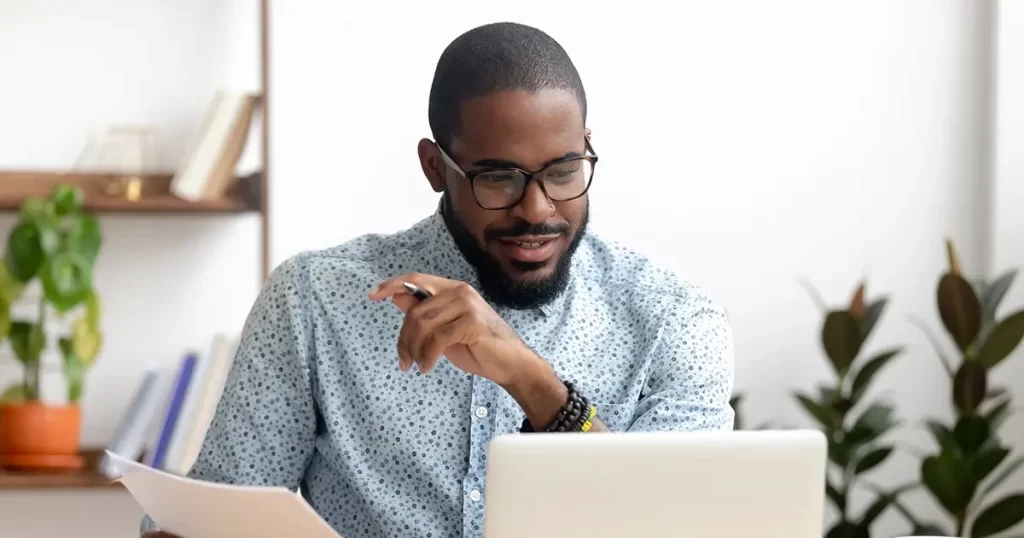 Man working at his laptop to improve business cash flow